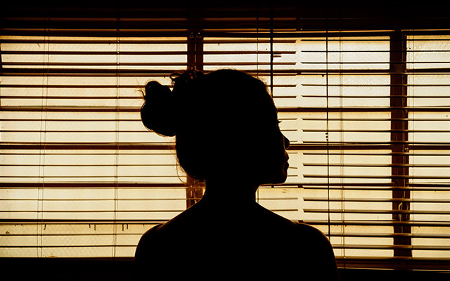 silhouette of a woman looking out a window